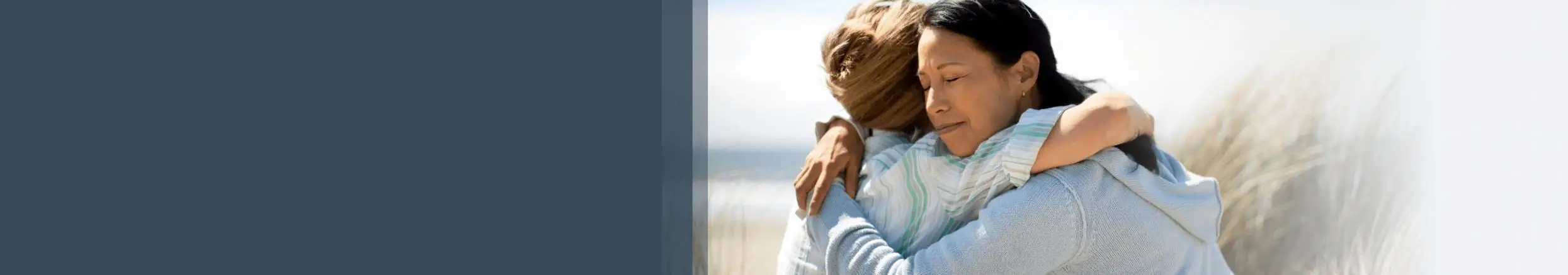 Na zewnątrz kobieta przytula inną na tle natury